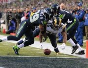 Seahawks safety Earl Thomas and Seahawks corner back Byron Maxwell pressure a fumble from Rams running back Benny Cunningham, which Thomas recovered for a touchback during the fourth quarter as the Seattle Seahawks play the St. Louis Rams at CenturyLink Field in Seattle on December 28, 2014. HAWKS V RAMS 12282014 143857